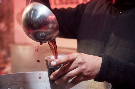 Mulhouse - France - 10 December 2017 - retail of barmaid hand with decorated mulled wine glass in the christmas marketのeditorial素材