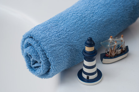 Closeup of blue rolled bath towel with ocean decoration in bathroomの写真素材