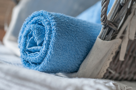 closeup of blue rolled bath towel in wooden basketの写真素材