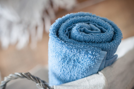 closeup of blue rolled bath towel in wooden basketの写真素材