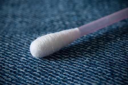 closeup of cotton swabs on blue jeans texture backgroundの写真素材