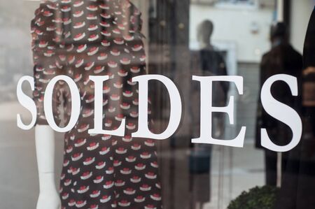 closeup of discount sign on window in french fashion store showroomの写真素材