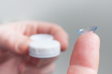 closeup of woman hand putting lenses of viewの写真素材