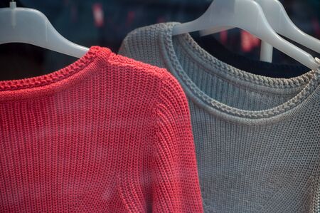 closeup of pullovers on hangers in fashion some showroom for women 