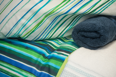 closeup of blue set of bed linen and rolled bath towel in storeの写真素材