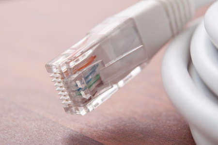 Closeup of   white Network Cable on wooden desk background