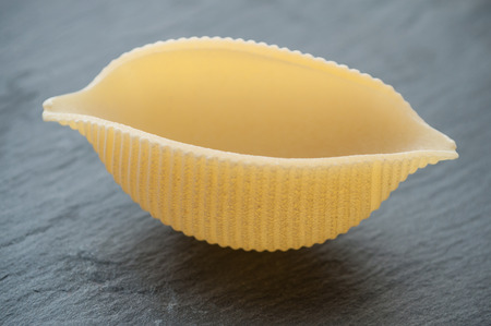 closeup of shaped seashell pasta on chalkboard backgroundの写真素材
