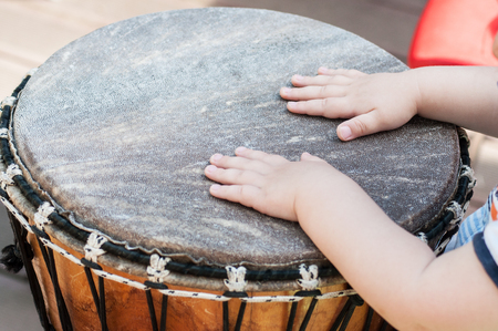 Closeup of baby's hands on African drums in outdoorの写真素材