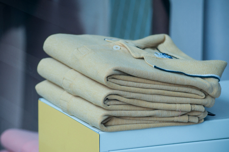 closeup of yellow polos stack in a men fashion storeの写真素材