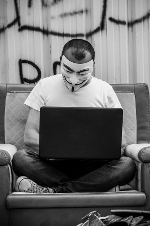 Paris - France - 19 May 2018 - portrait of man with Vendetta mask and coumputer in abandoned ...