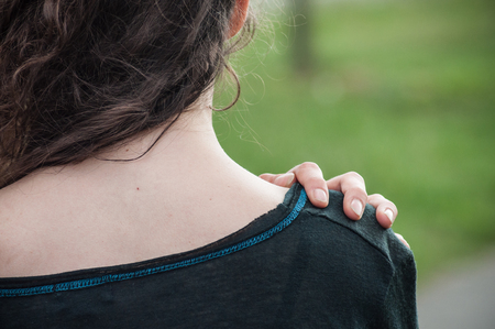 closeup of attractive woman neck with hand in outdoor の写真素材