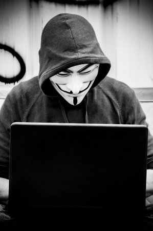 Paris - France - 19 May 2018 - portrait of man with Vendetta mask and coumputer in abandoned ...