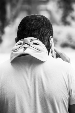 Paris - France - 19 May 2018 - portrait of man with Vendetta mask and telephone  in outdoor. This...