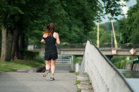 Mulhouse - France - 6 June 2018 - Woman running in border channelのeditorial素材