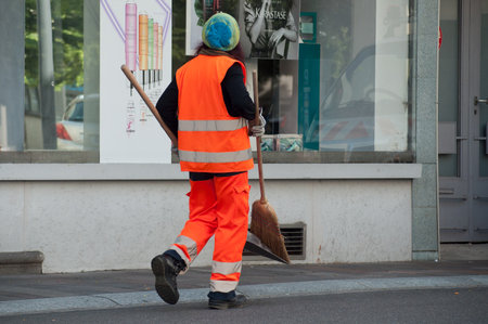 Mulhouse - France - 3 June 2018 - Woman municipal employee walking with shovel and broom in handのeditorial素材
