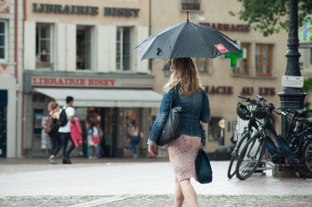 Mulhouse - France - 7 June  2018 -  portrait of woman with umbrella on cobbles place in the cityのeditorial素材