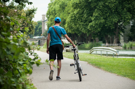 Mulhouse - France - 17 June 2018 - man walking  next to  mountain bike in border water