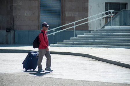 Mulhouse - France - 28 June 2018 - chines man walking with suitcase from the train stationのeditorial素材