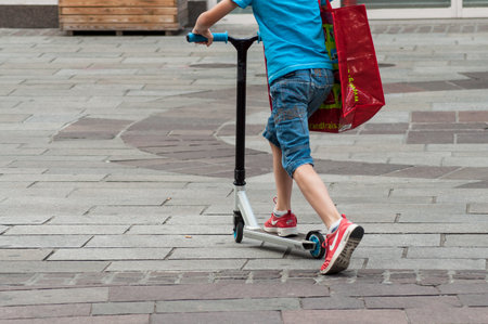Mulhouse - France - 3 July 2018 - closeup of little boy on scooter in the street on back view