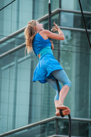 Mulhouse - France - 13 July 2018 - Portrait of a young blond woman climbing rope for an outdoor aerobatics show in Mulhouseのeditorial素材