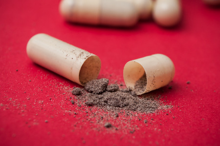 closeup of open capsule  on red background