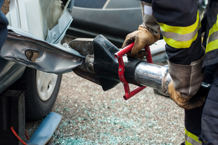 closeup of rescue man with pneumatic machine on crashed carの写真素材