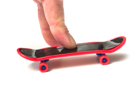 closeup of fingers on miniature skate board on white backgroundの写真素材