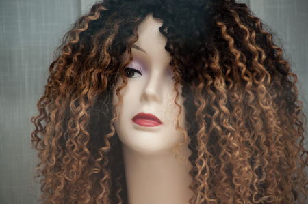 closeup of woman face of mannequin with afro wig in fashion store showroomの写真素材