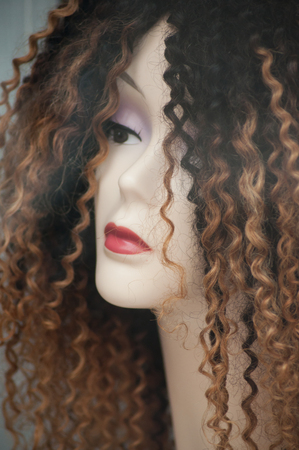 closeup of woman face of mannequin with afro wig in fashion store showroomの写真素材