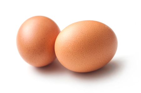 closeup of two organic eggs on white backgroundの写真素材