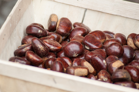 Closeup of chestnuts in wooden basket at the marketの写真素材