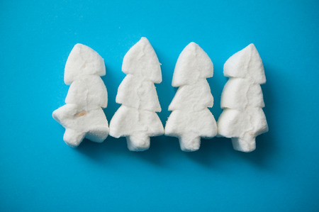 closeup of white marshmallows in shaped fir on blue background