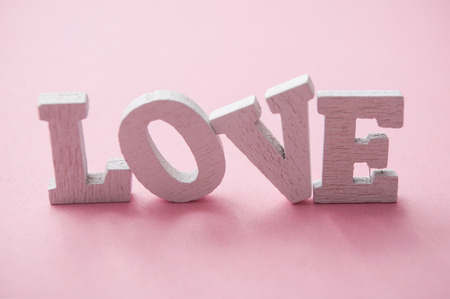 closeup of word love in wooden letters on pink backgroundの写真素材