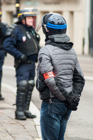 Mulhouse - France - 10 December 2018 - french civil policeman with helmet during the riot of high school students on the sidelines of the movement of yellow vests on CRS policemen backgroundのeditorial素材