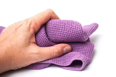closeup of purple cleaning towel in hand on white backgroundの写真素材