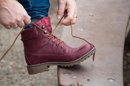 closeup of feet of woman with red winter boot in urban parkの写真素材
