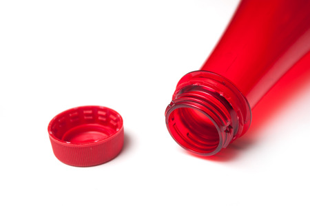 closeup of open red plastic bottle neck on white backgroundの写真素材
