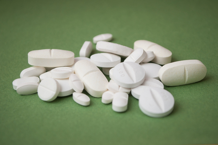 closeup of white pils on green backgroundの写真素材