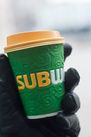 Mulhouse - France - 25 January 2019 - closeup of man with gloves taking in hand a paper cup of coffee for take away from subway brand  in the streetのeditorial素材