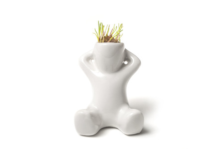 closeup of plant pot in shaped man with grass in his head on white backgroundの写真素材