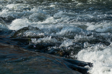 Closeup of water and rocks in the river on mountainの写真素材
