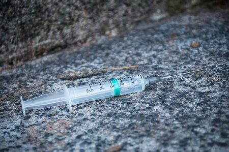 closeup of syringue abandoned on the floor in the streetの写真素材