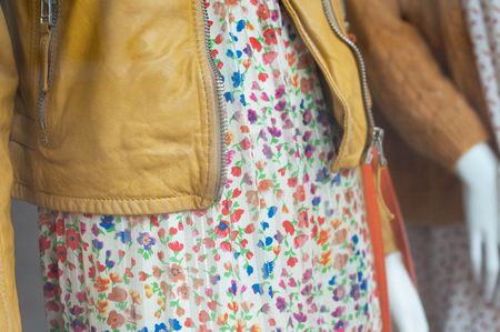 closeup of yellow leather vest and summer dress on mannequin  in women fashion store showroomの写真素材
