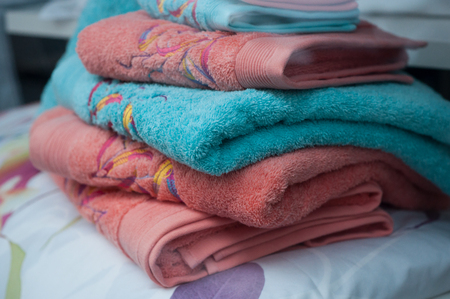 closeup of colorful bath towels pile on bed in decoration store showroomの写真素材