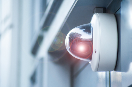 closeup of security camera on modern building with flareの写真素材