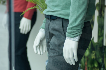 closeup of green and red pullover on mannequin in fashion store showroom for menの写真素材