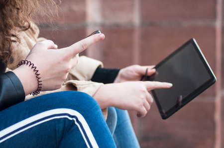 closeup of girls surfing on tablet in the streetの写真素材