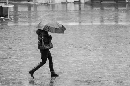 Mulhouse - France - 3 April 2019 -  portrait of woman with black umbrella on cobbles place in the cityのeditorial素材