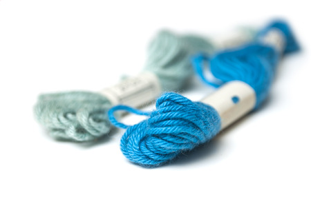 closeup of blue cotton threads on white background