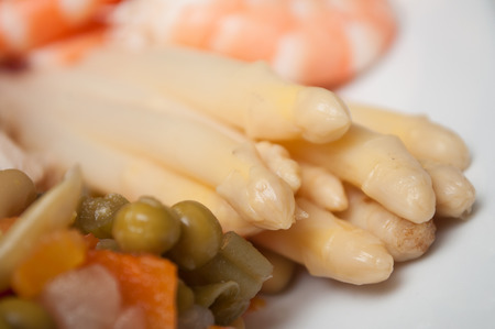closeup of white asparagus with vegetables in a plateの写真素材